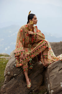 Woman in a floral dress sitting on a rock with a scenic background