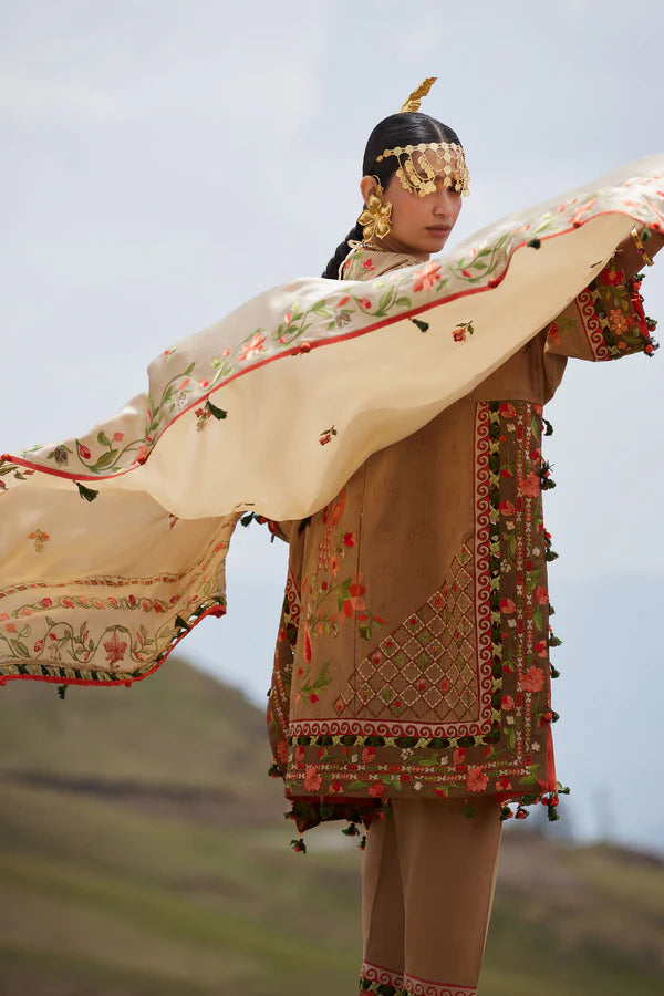 Person wearing traditional embroidered clothing with a scenic background