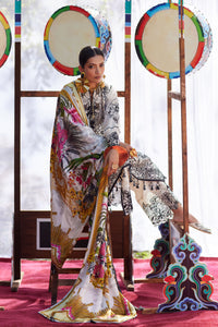 Woman in a patterned outfit sitting on a decorative chair with colorful drums in the background.