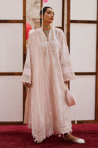 Woman in a traditional outfit with lace details standing against a wooden panel background.