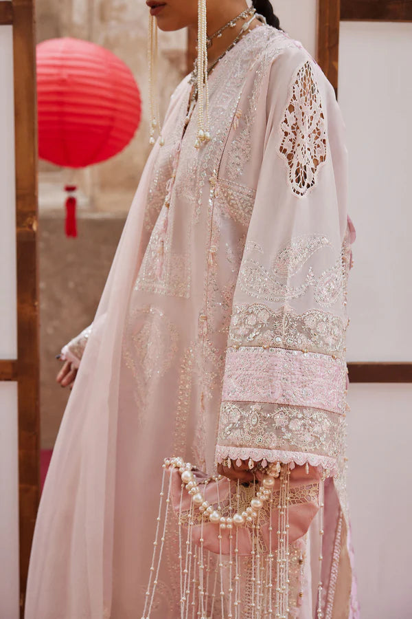 Person wearing a traditional embroidered outfit with a red lantern in the background