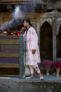 Woman in traditional attire standing in front of a temple with incense sticks.