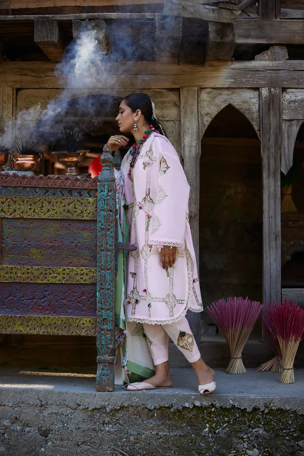 Woman in traditional attire standing in front of a temple with incense sticks.