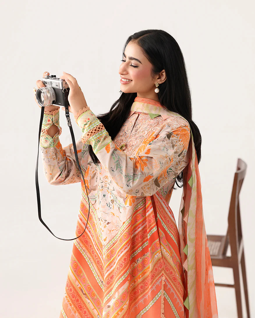 Woman in a patterned outfit holding a camera on a white background