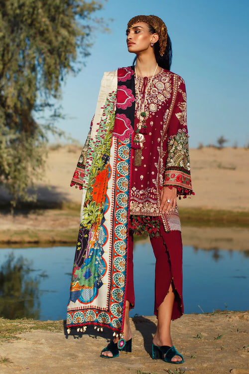 Woman in traditional outfit with a colorful scarf by a lake