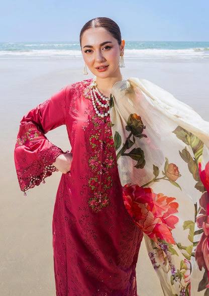 Woman in a red traditional outfit with a floral scarf on a beach