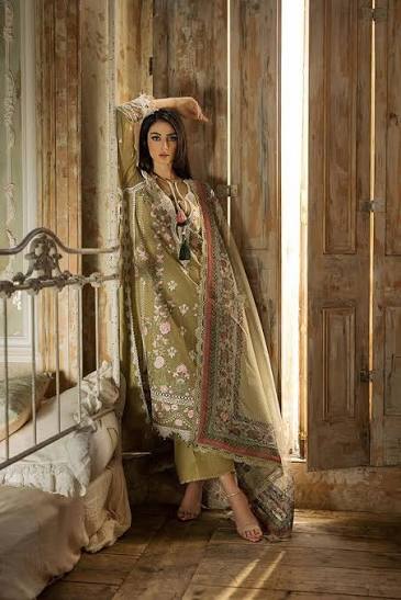 Woman in traditional attire standing in a rustic room with wooden walls and a bed.