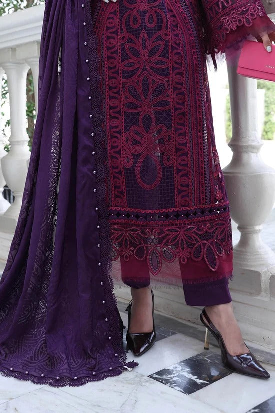 Person wearing a dark purple traditional outfit with intricate patterns on a light background