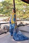 Woman in a yellow and blue dress standing near zebras at a zoo.