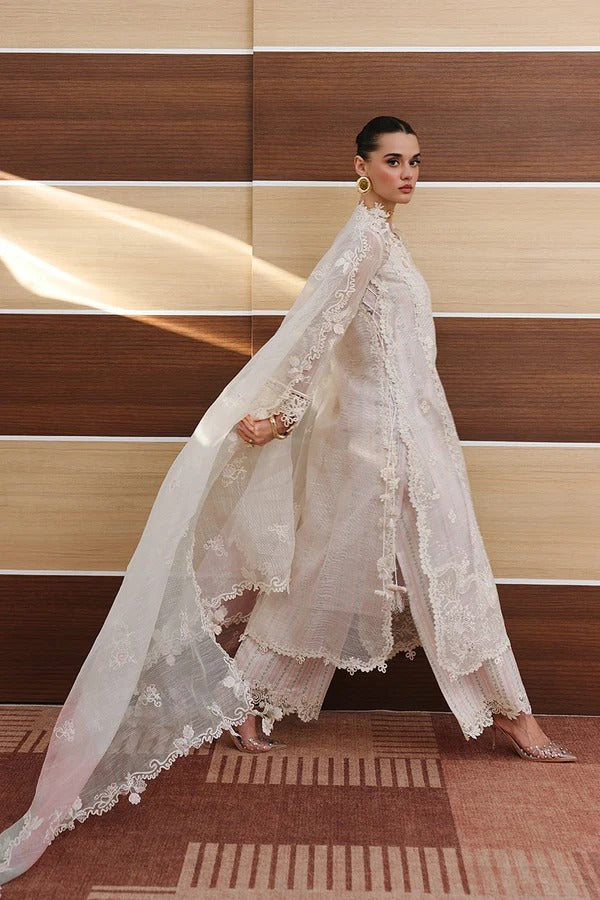 Model wearing a white lace outfit against a wooden panel background