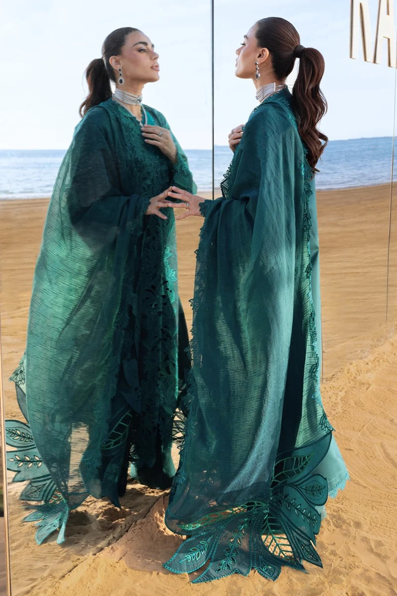 Woman in a teal outfit standing on a beach with ocean view