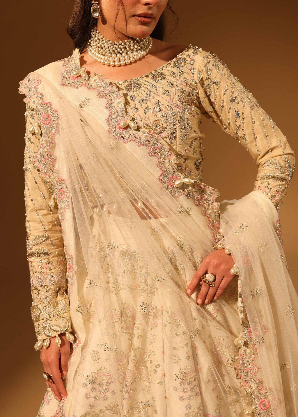 Woman wearing a traditional embroidered outfit with a beige background