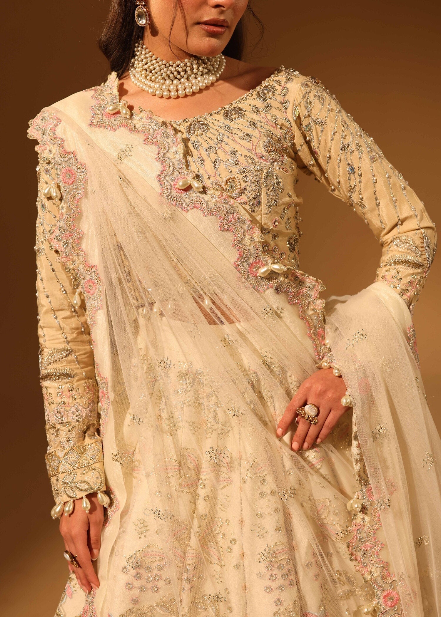 Woman wearing a traditional embroidered outfit with a beige background