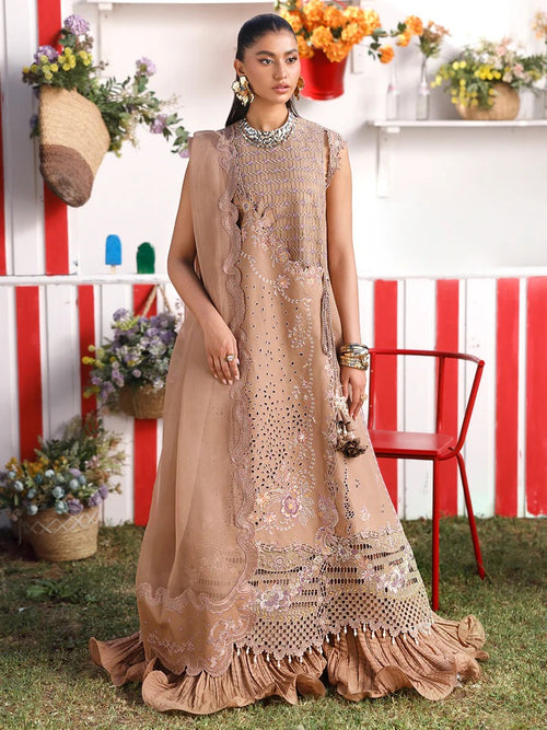Woman in a beige embroidered dress standing outdoors with a colorful background