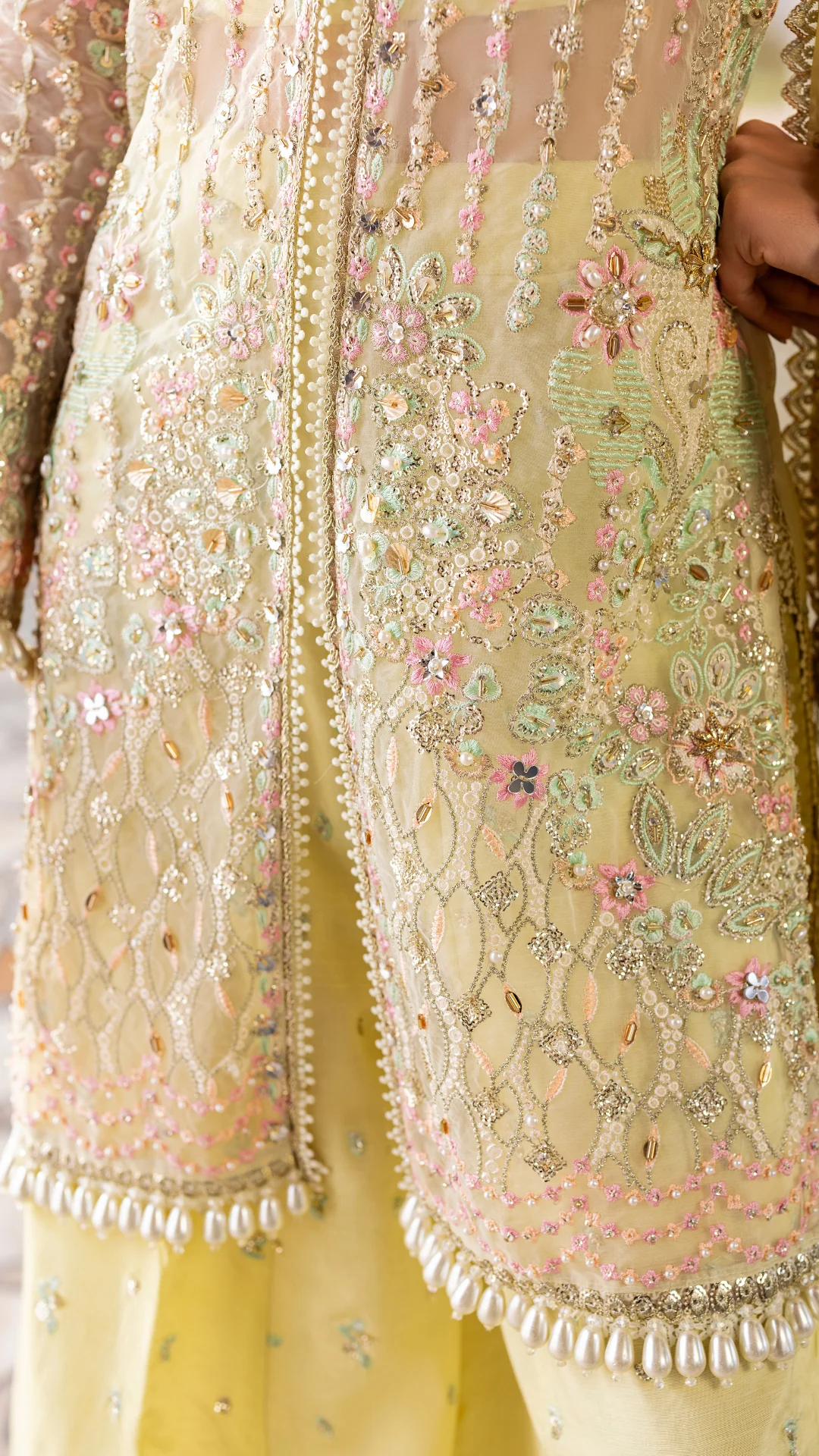 Close-up of a embroidered traditional outfit with floral patterns and beaded details.