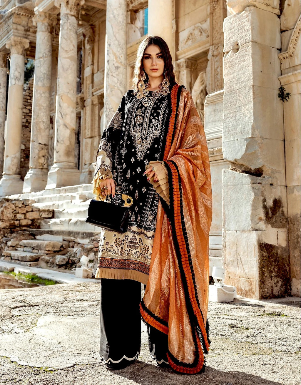 Woman in traditional outfit standing in front of ancient stone architecture