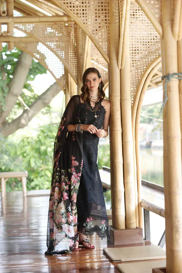 Woman in a black dress with floral sleeves standing in a bamboo structure