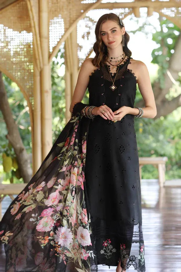 Woman wearing a black sleeveless dress with floral shawl in an outdoor setting