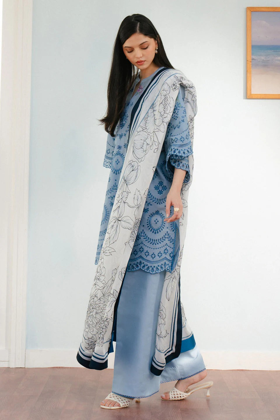 Woman wearing a blue and white patterned outfit with a matching scarf indoors.