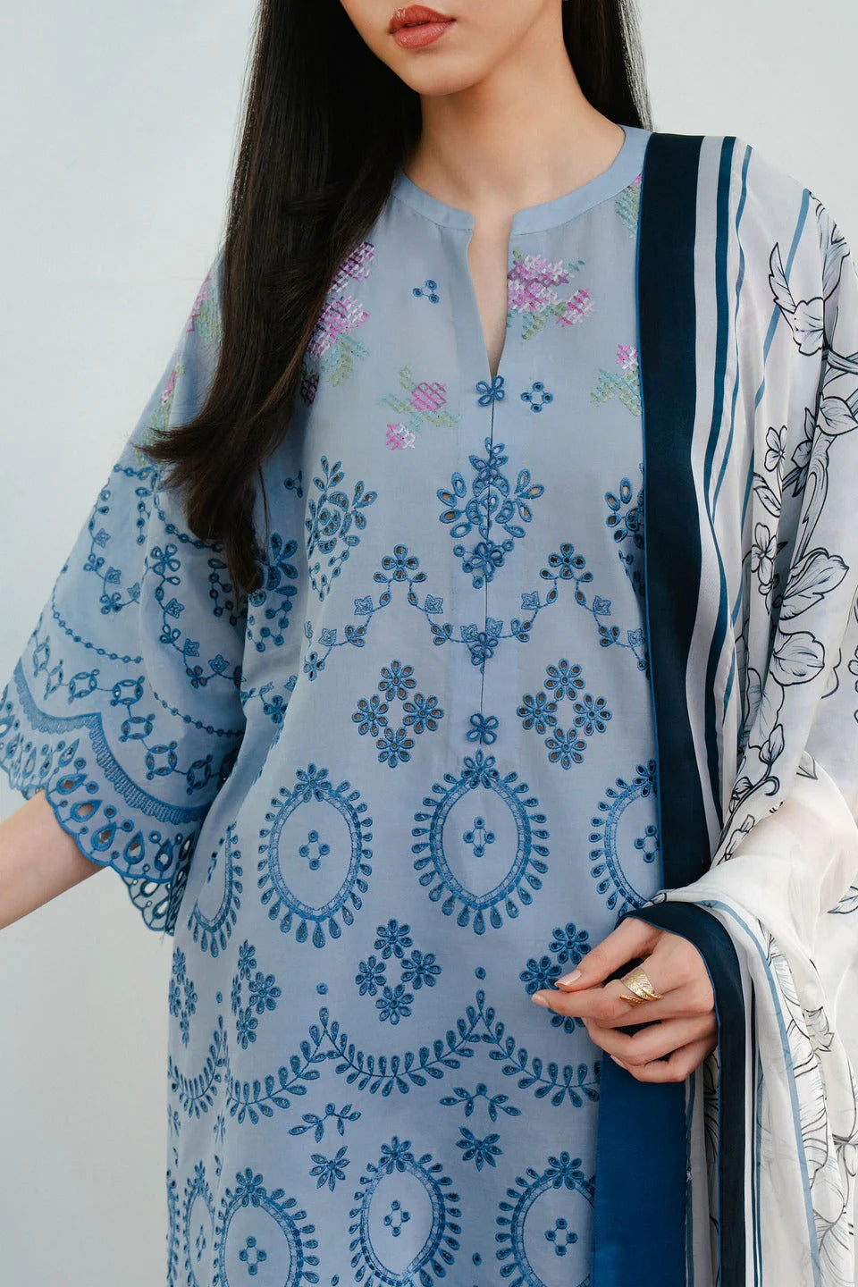 Woman wearing a blue and white patterned dress with a plain background