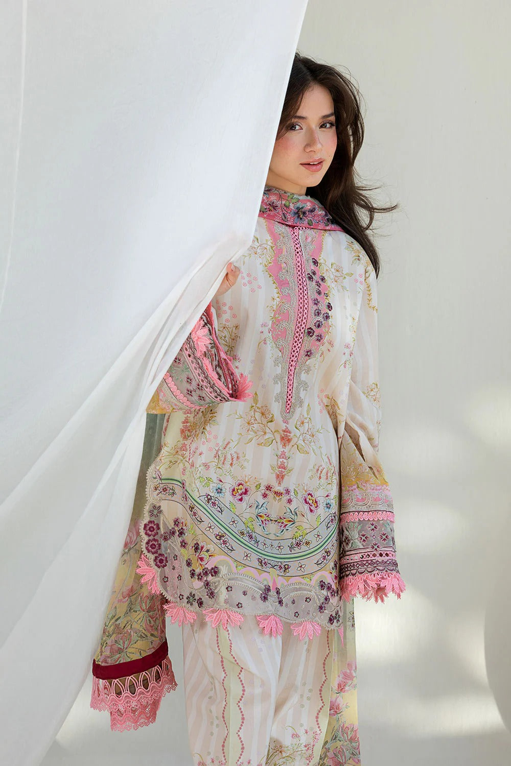 Woman wearing a floral embroidered outfit with a white background