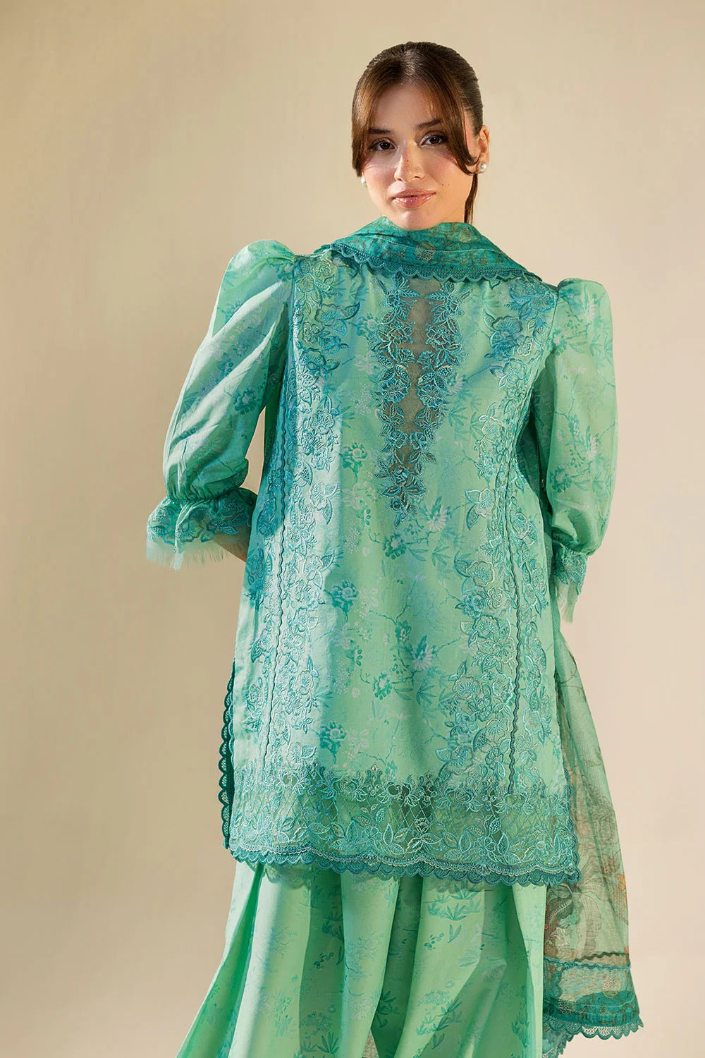 Woman wearing a light green traditional outfit with a beige background