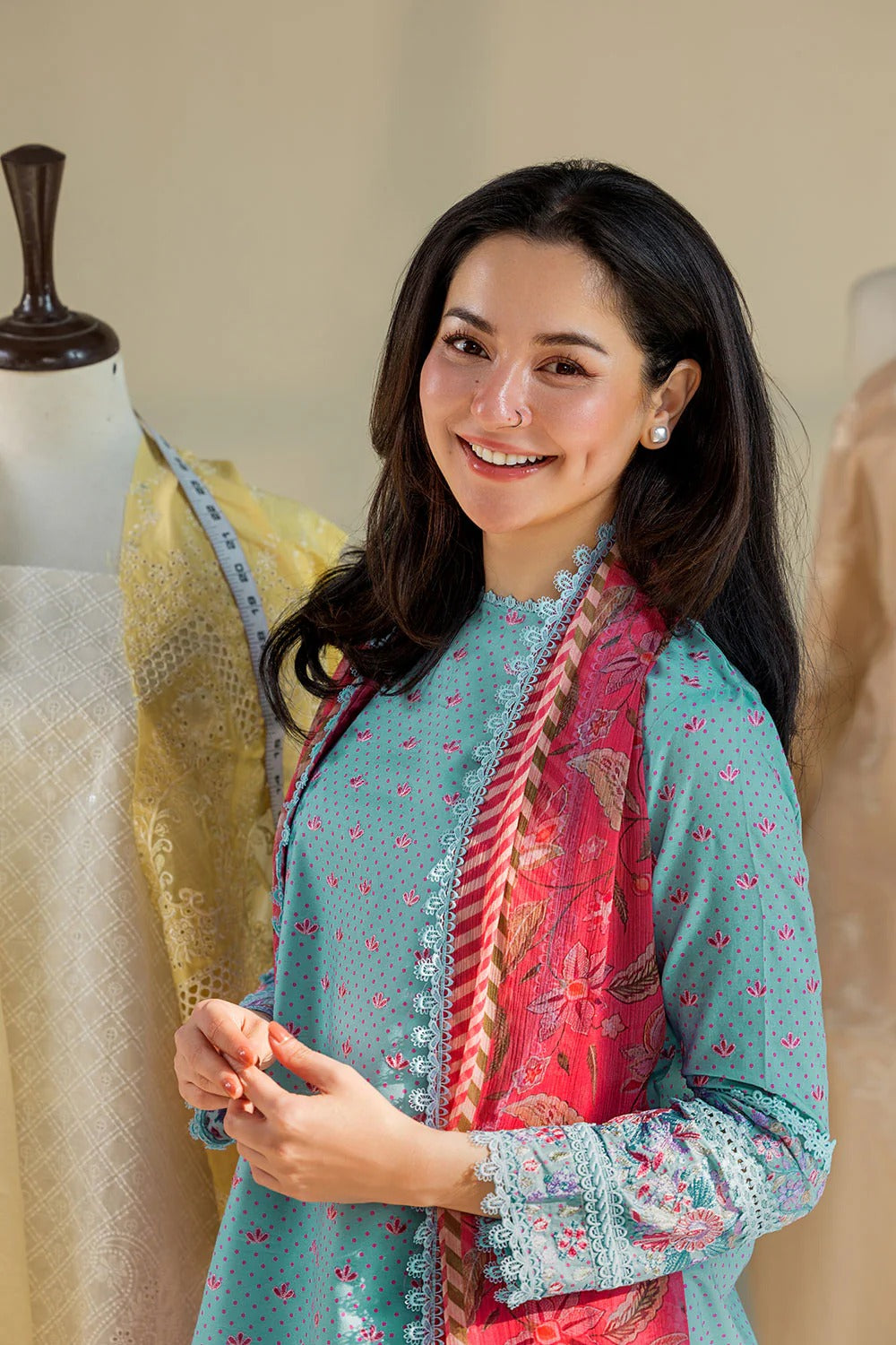 Woman wearing a colorful traditional outfit with mannequins in the background