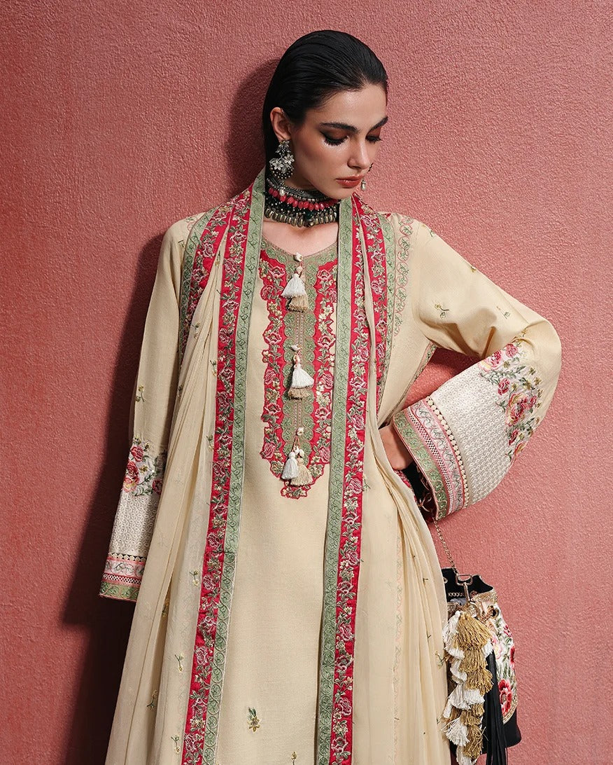 A woman models a traditional beige embroidered kurta set with a matching dupatta and a red floral embroidered jacket, posed against a textured pink wall.