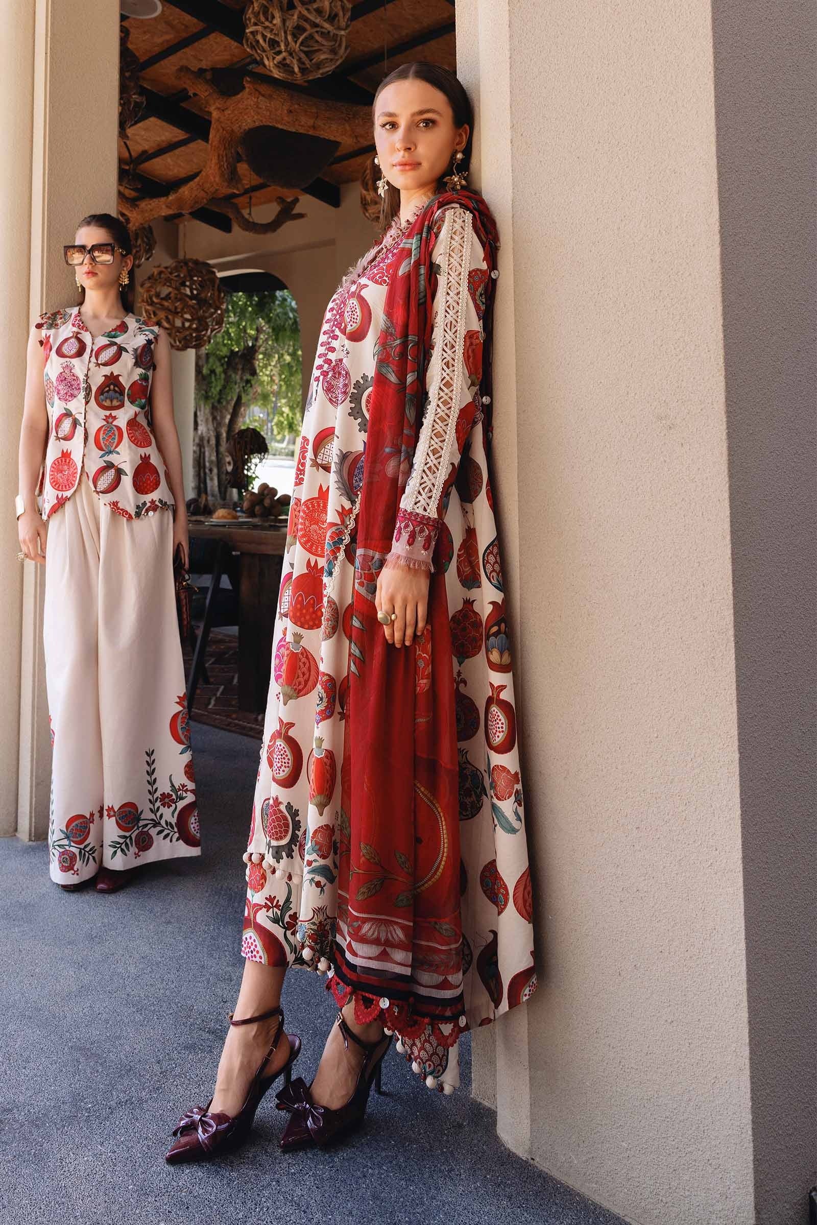 Woman in a floral dress standing next to a mirror reflection in an indoor setting.