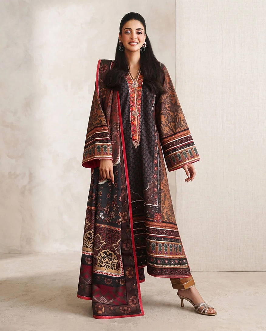 A woman models a traditional South Asian outfit consisting of a dark brown printed kurta with red borders and a matching printed jacket, set against a neutral textured beige background.