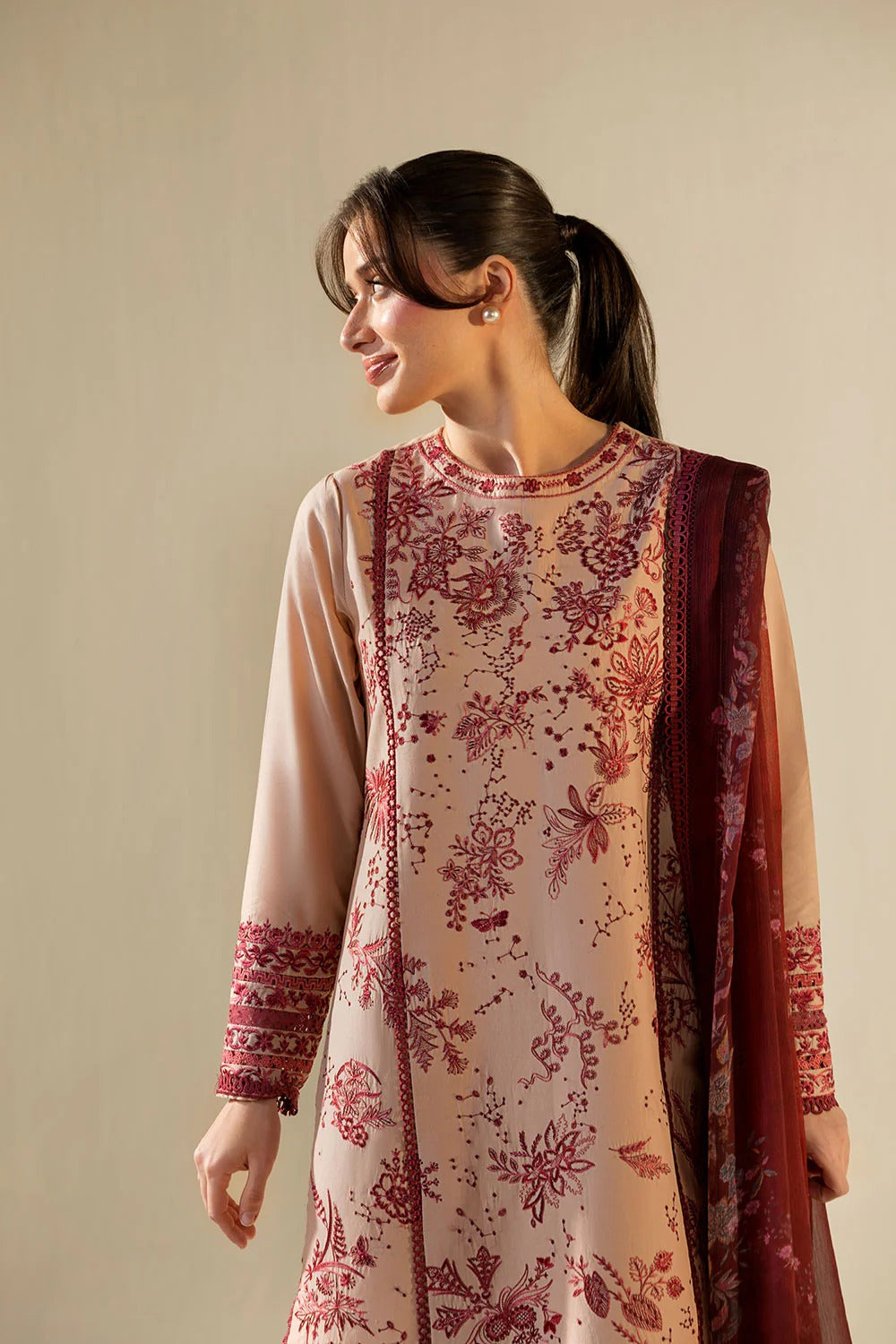 Woman wearing a traditional outfit with floral patterns on a beige background