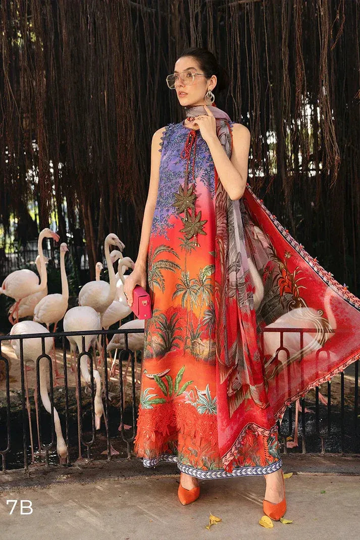 Woman in a colorful dress with a pattern of flamingos and birds, standing in front of flamingo enclosure.