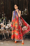 Woman in a colorful dress with a pattern of flamingos and birds, standing in front of flamingo enclosure.