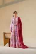 Woman wearing a traditional outfit with a pink and red patterned shawl against a neutral background