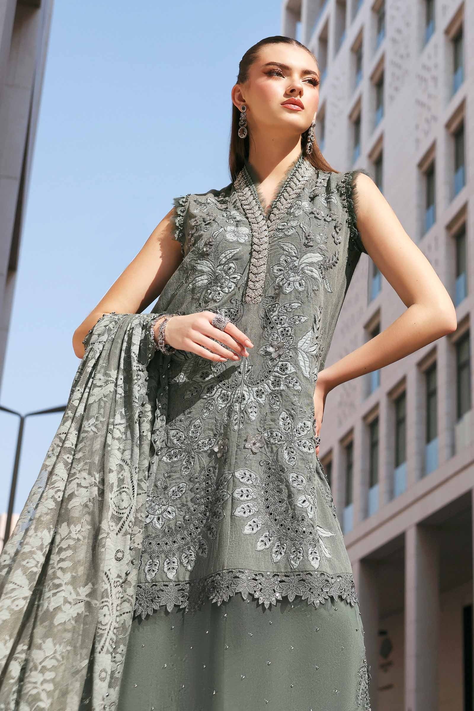 Woman wearing a gray embroidered outfit with a building in the background