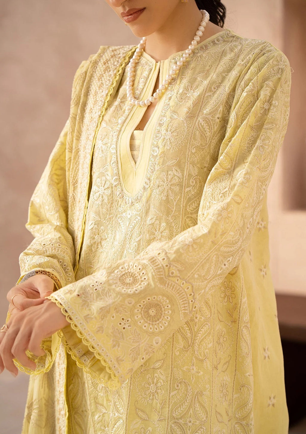 Yellow embroidered traditional outfit with a plain background