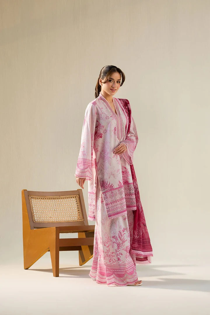 Woman wearing a pink and white patterned outfit standing next to a wooden chair on a plain background