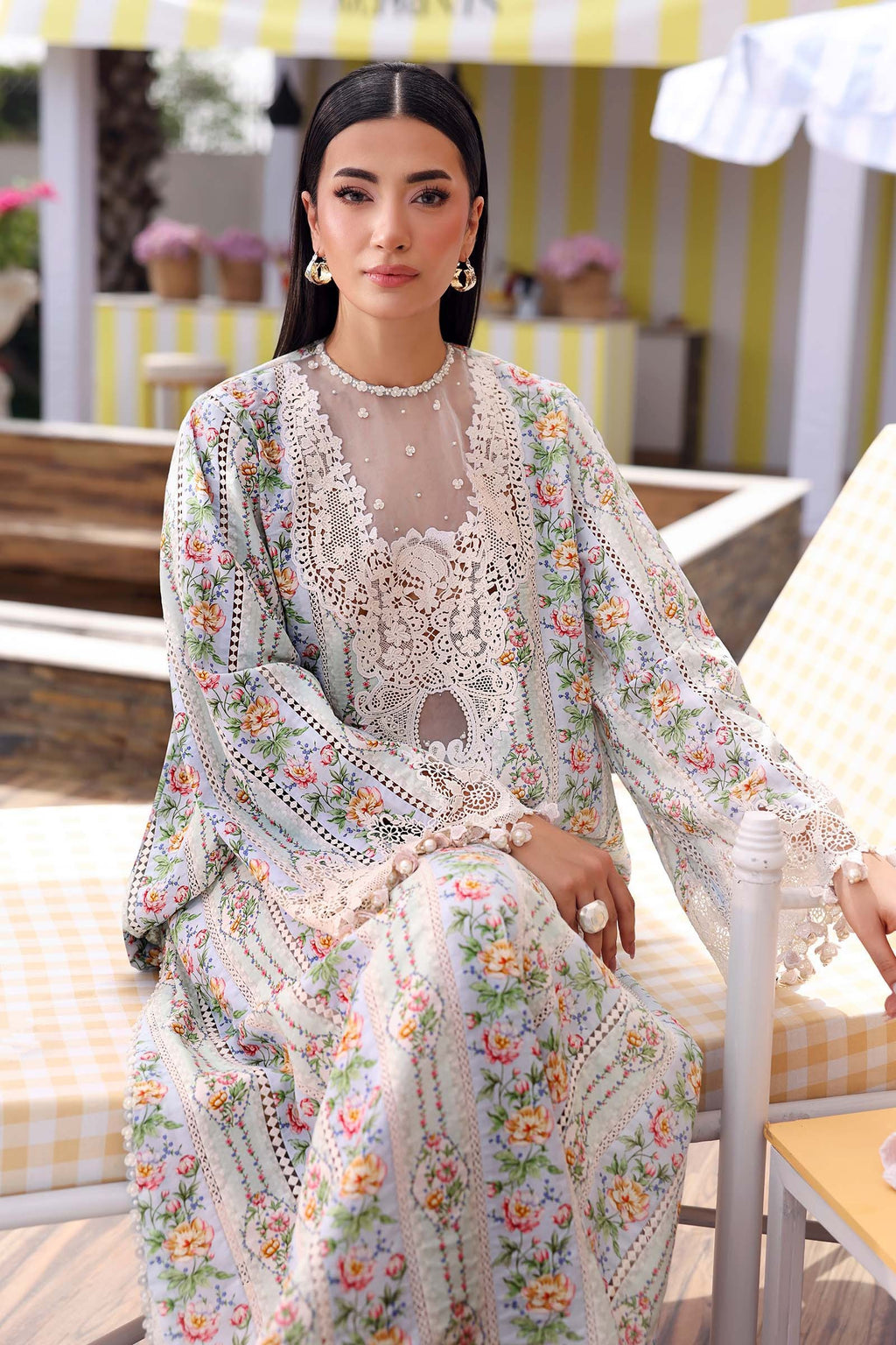 Woman wearing a floral embroidered outfit sitting outdoors.