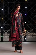 A woman models a traditional South Asian outfit featuring a black kurta with red and green floral embroidery, a matching red dupatta, and black trousers, set against a dark geometric studio background with illuminated lights.