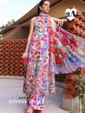 A woman models a three-piece floral print salwar kameez suit with a matching dupatta. The outfit features a white base with vibrant pink, red, purple, and green floral patterns.
