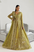 A woman models a traditional Indian anarkali gown in olive green with intricate gold embroidery and a matching embroidered dupatta, posed in front of a light gray sofa.