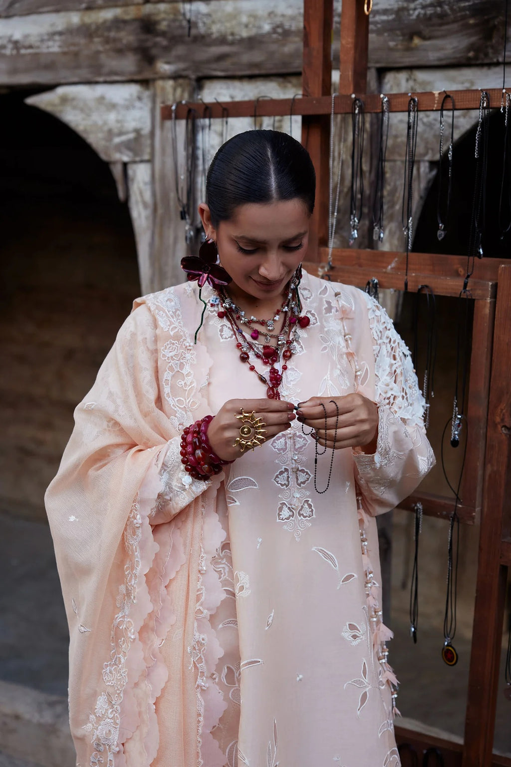 Woman in traditional attire with jewelry in a rustic setting