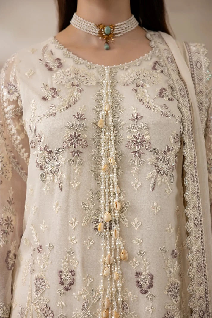 Close-up of a cream-colored traditional embroidered outfit with intricate floral embroidery in beige, white, and muted purple tones, adorned with a beaded tassel down the center and a matching pearl choker necklace.