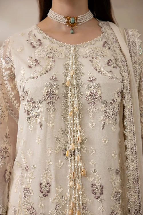 Close-up of a cream-colored traditional embroidered outfit with intricate floral embroidery in beige, white, and muted purple tones, adorned with a beaded tassel down the center and a matching pearl choker necklace.