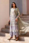 Woman in a traditional outfit standing on steps with a neutral background