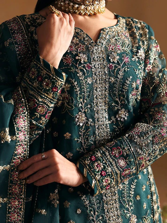 Close-up of a person wearing a heavily embroidered traditional outfit with intricate patterns.