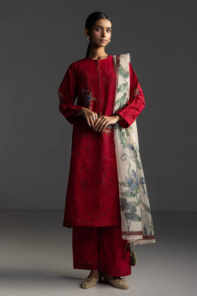 Woman wearing a red traditional outfit with a patterned scarf on a gray background