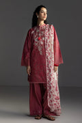 Woman wearing a traditional outfit with a maroon kurta, palazzo pants, and a floral dupatta against a gray background.