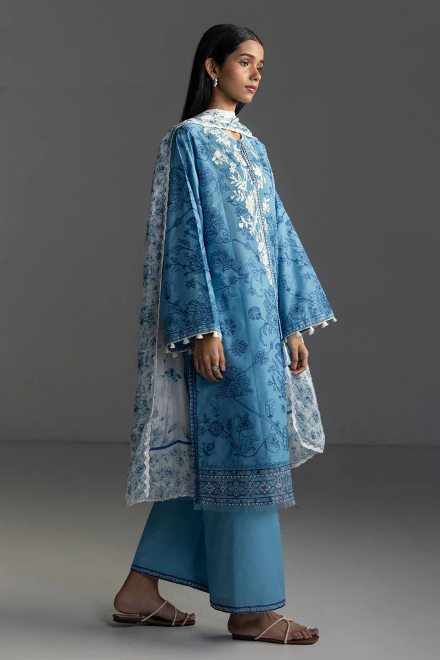 Woman wearing a blue embroidered traditional outfit on a gray background