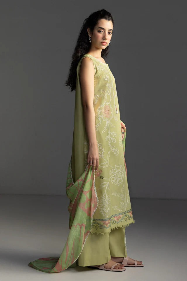 Woman wearing a light green traditional outfit with a matching dupatta on a gray background